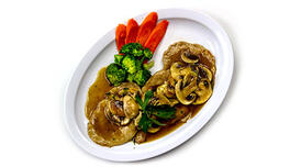 A plate of Chicken Marsala with cooked broccoli and sliced carrots on the side